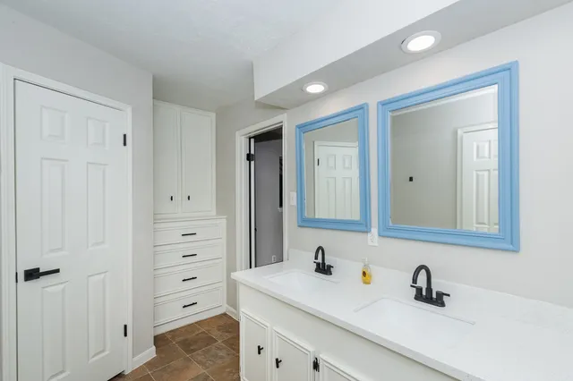 a bathroom with a double vanity sink and mirror