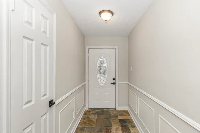 a living room with furniture a fireplace a flat screen tv and a large window