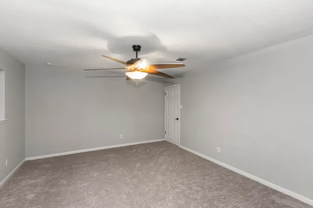 a view of a livingroom with a ceiling fan and window