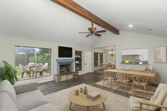 a view of an empty room with wooden floor fireplace and a window