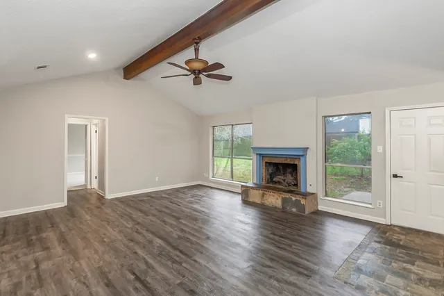 an empty space with wooden floor and windows