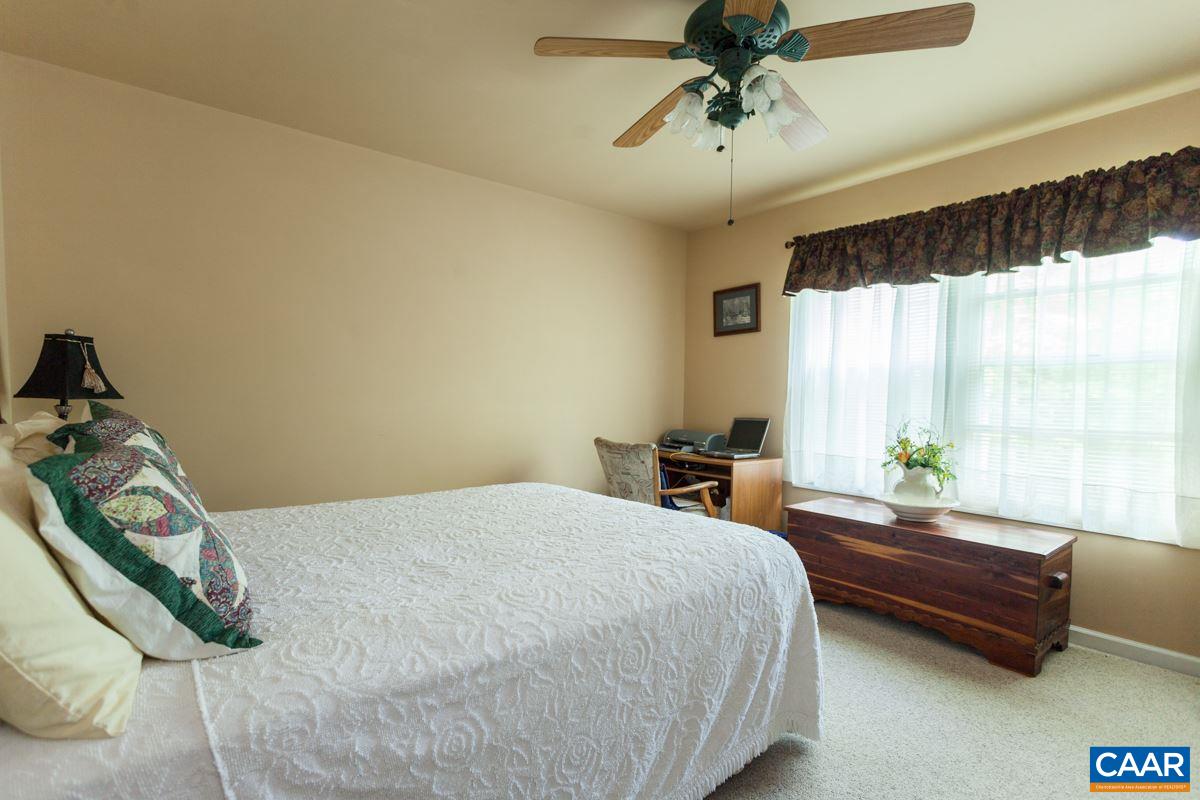 46 Riverside Drive Palmyra, VA 22963 - Photo 11 of 19 a bedroom with a bed and a chandelier
