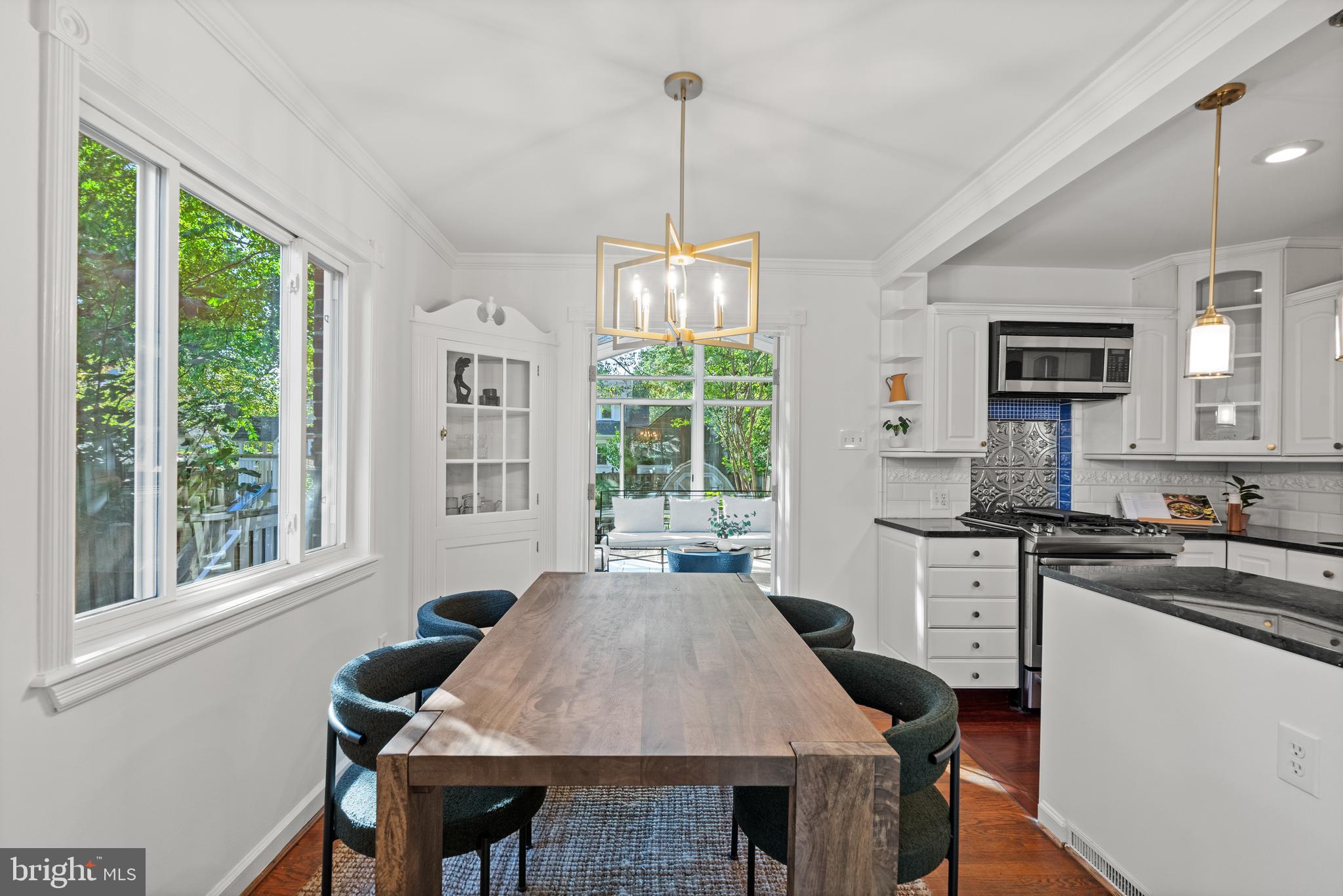 307 East Oxford Avenue, Unit 1/2 Alexandria, VA 22301 - Photo 10 of 34 a kitchen with a stove a sink dishwasher a dining table and chairs with wooden floor