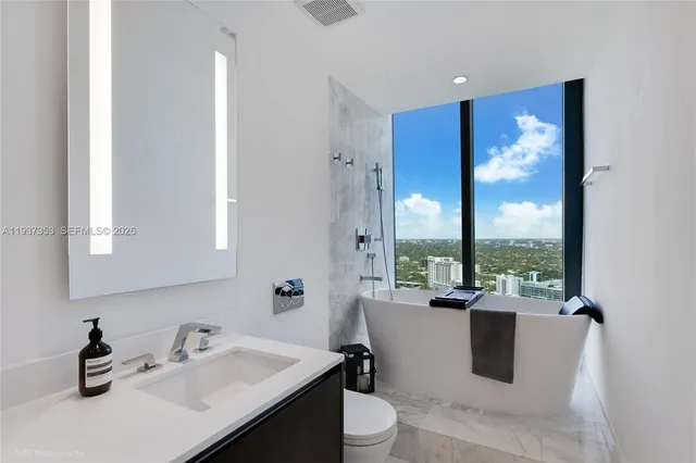 a bathroom with a double vanity sink toilet and mirror