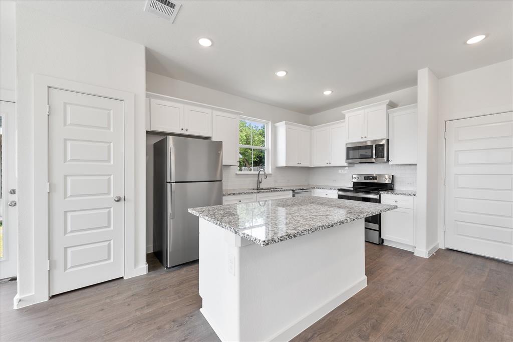 1215 Chestnut Court Runaway Bay, TX 76426 - Photo 11 of 28 a kitchen with stainless steel appliances granite countertop a refrigerator a stove a sink and a refrigerator