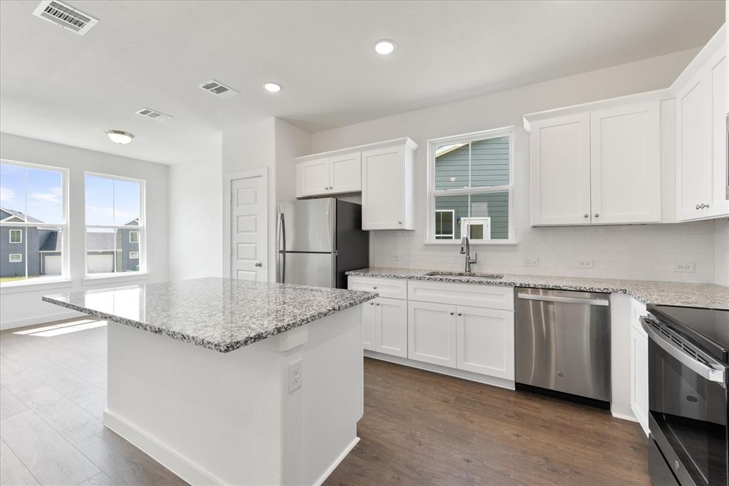 1215 Chestnut Court Runaway Bay, TX 76426 - Photo 12 of 28 a kitchen with stainless steel appliances granite countertop a sink stove and refrigerator