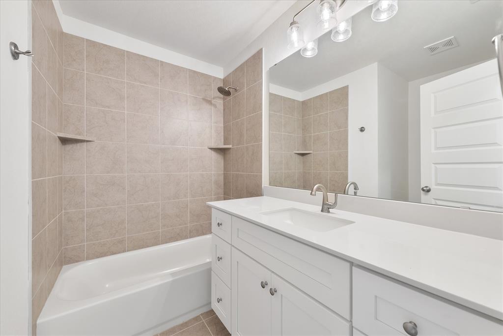 1215 Chestnut Court Runaway Bay, TX 76426 - Photo 25 of 28 a bathroom with a sink a vanity a mirror and a bathtub