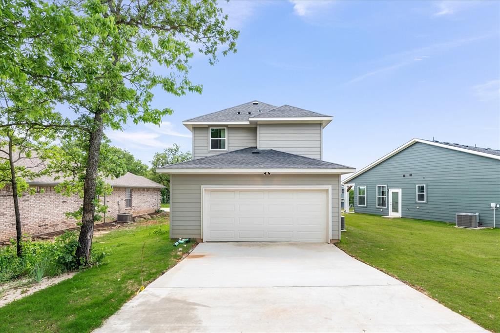 1215 Chestnut Court Runaway Bay, TX 76426 - Photo 26 of 28 a front view of a house with a yard and garage