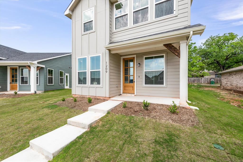1215 Chestnut Court Runaway Bay, TX 76426 - Photo 4 of 28 front view of a brick house with a yard