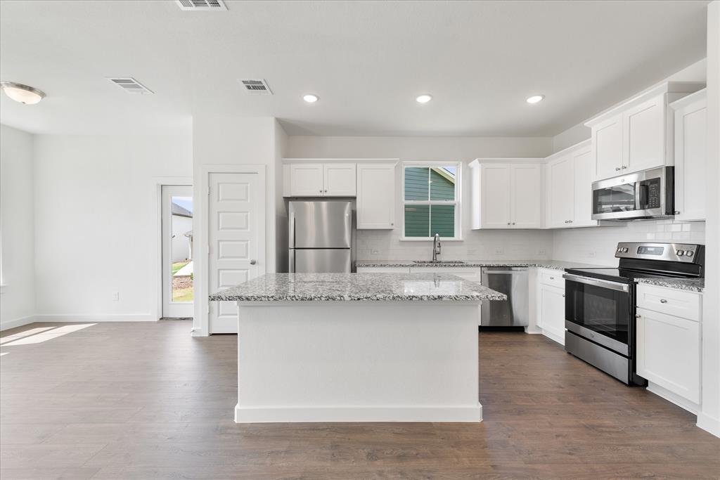 1215 Chestnut Court Runaway Bay, TX 76426 - Photo 10 of 28 a kitchen with stainless steel appliances granite countertop a stove a sink and a microwave
