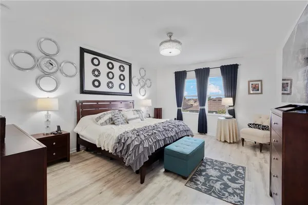 a bedroom with a bed and dresser with mirror