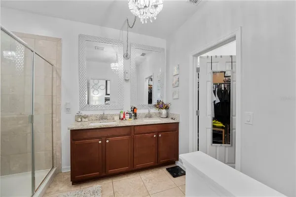 a bathroom with a double vanity sink a toilet and shower