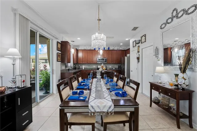 a view of a dining room with furniture a kitchen and chandelier