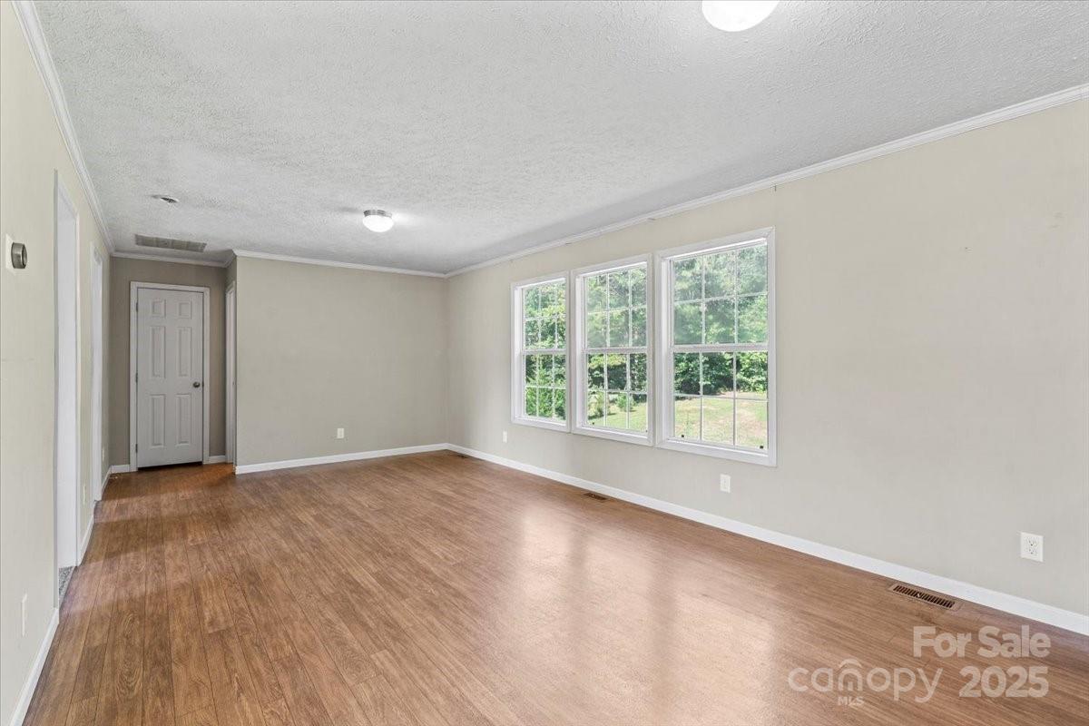 138 Dayton Road Dallas, NC 28034 - Photo 3 of 26 an empty room with wooden floor and windows