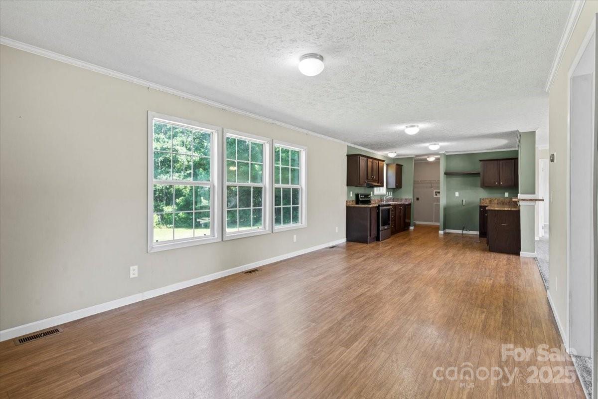 138 Dayton Road Dallas, NC 28034 - Photo 4 of 26 an empty room with wooden floor and windows