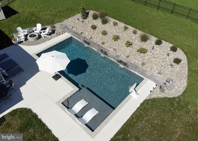 a view of a backyard with table and chairs under an umbrella