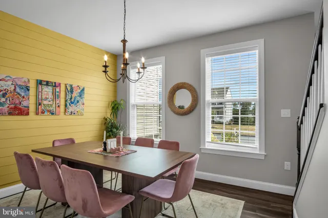 a view of a dining room with furniture a chandelier and wooden floor