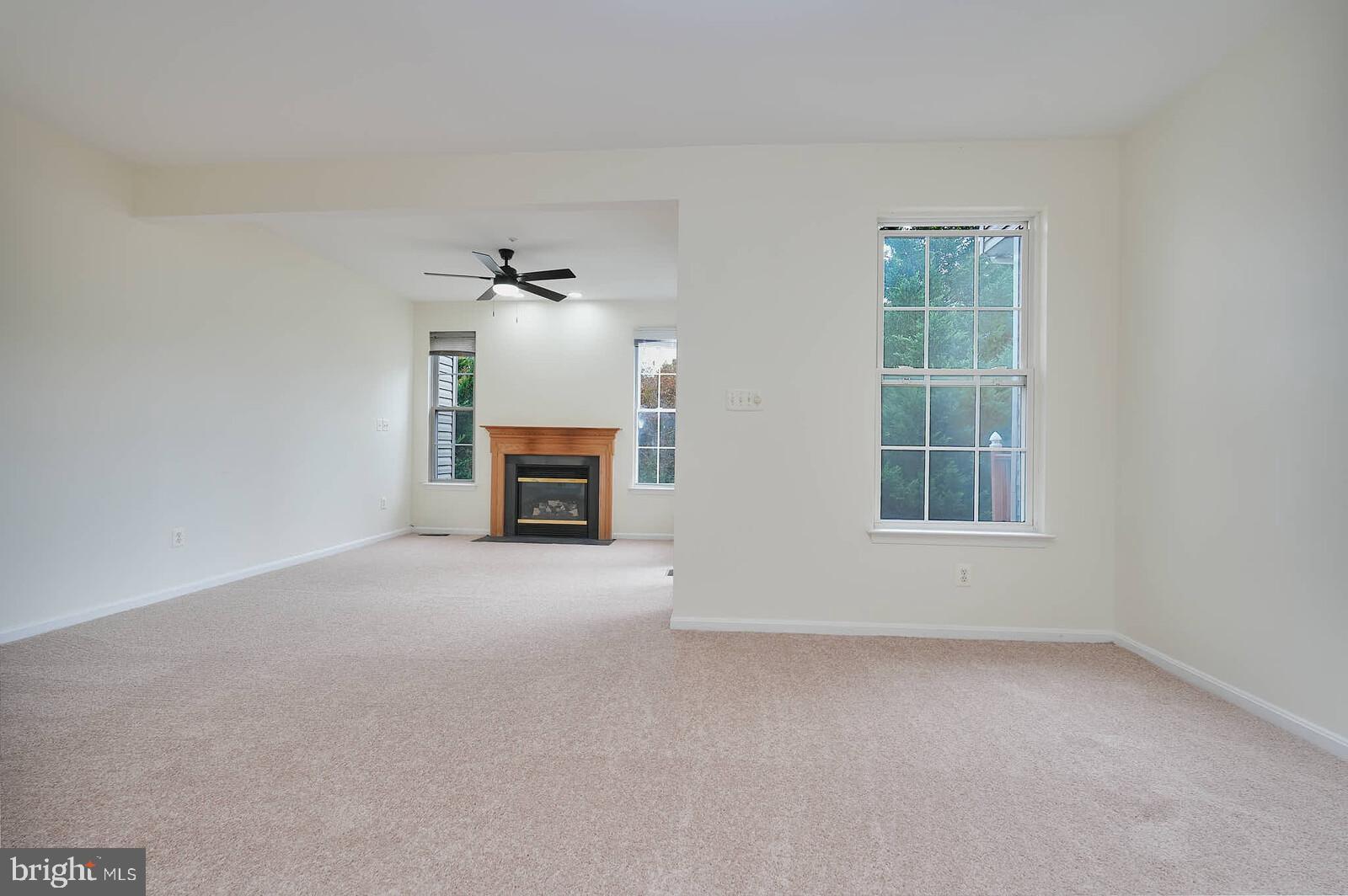 7802 Canter Court Severn, MD 21144 - Photo 12 of 41 an empty room with a fireplace and window
