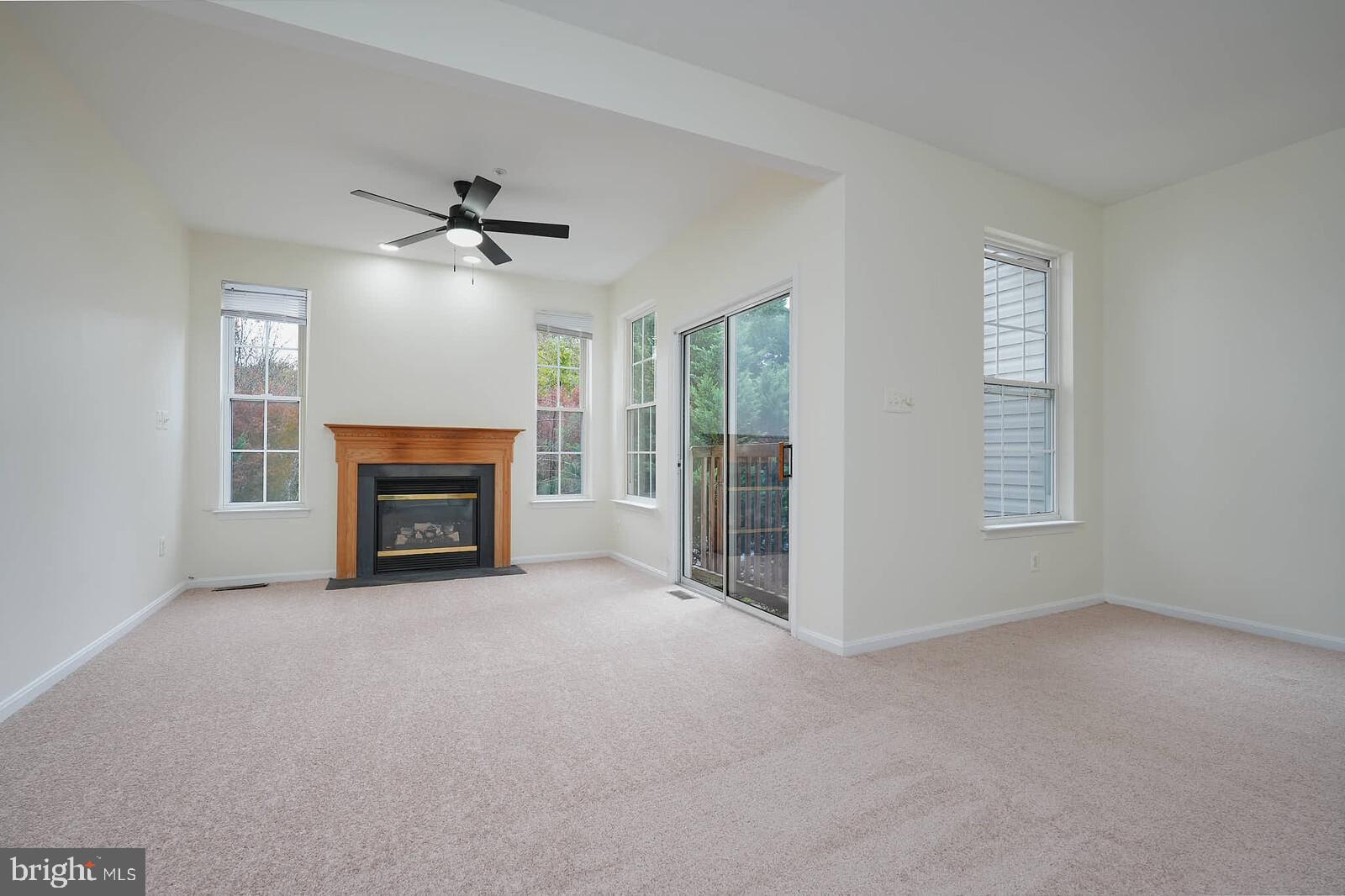 7802 Canter Court Severn, MD 21144 - Photo 13 of 41 an empty room with windows fireplace and fan