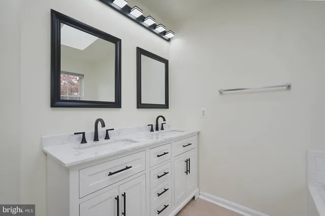 a bathroom with 2 sink and a mirror