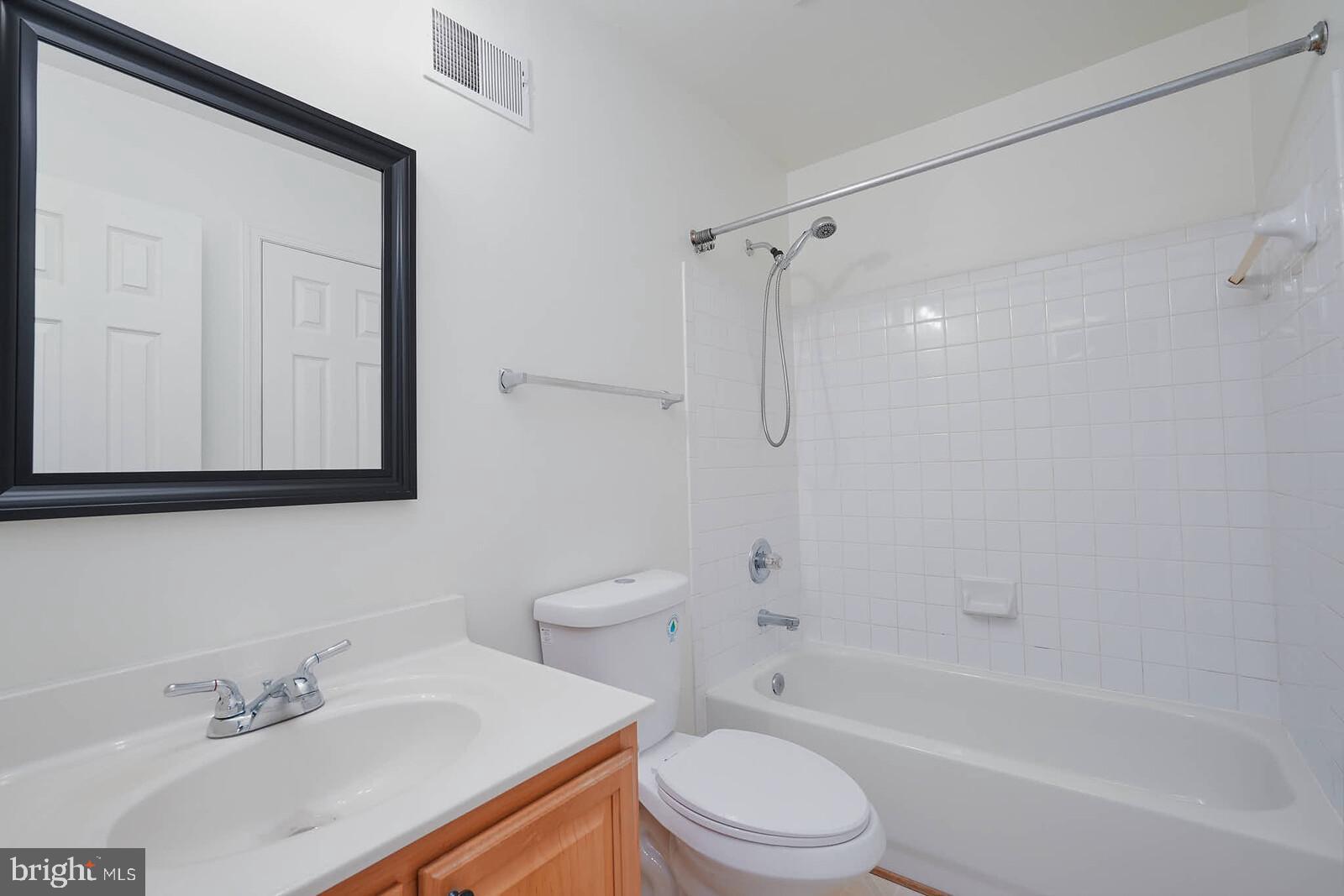 7802 Canter Court Severn, MD 21144 - Photo 30 of 41 a bathroom with a bathtub shower sink vanity mirror and toilet