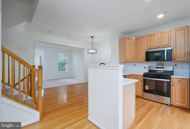 a kitchen with granite countertop a refrigerator and a stove top oven