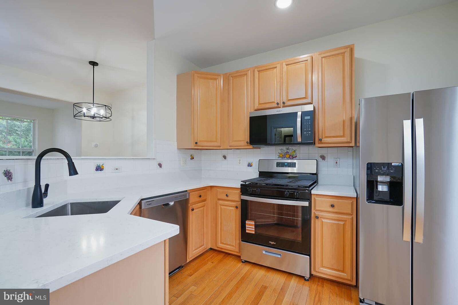7802 Canter Court Severn, MD 21144 - Photo 5 of 41 a kitchen with stainless steel appliances granite countertop a stove a sink dishwasher and a refrigerator with wooden floor