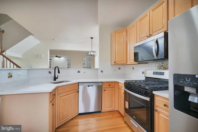 a kitchen with stainless steel appliances granite countertop a sink stove and microwave