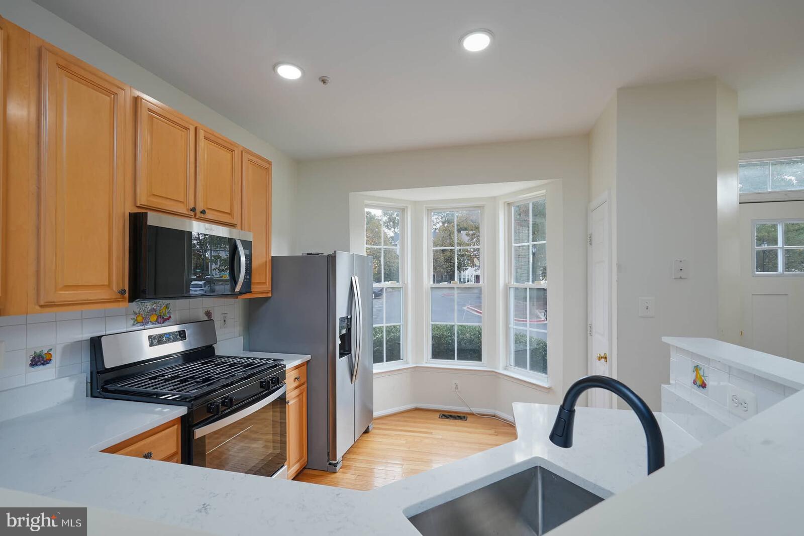 7802 Canter Court Severn, MD 21144 - Photo 8 of 41 a kitchen with stainless steel appliances granite countertop a stove a sink and a refrigerator