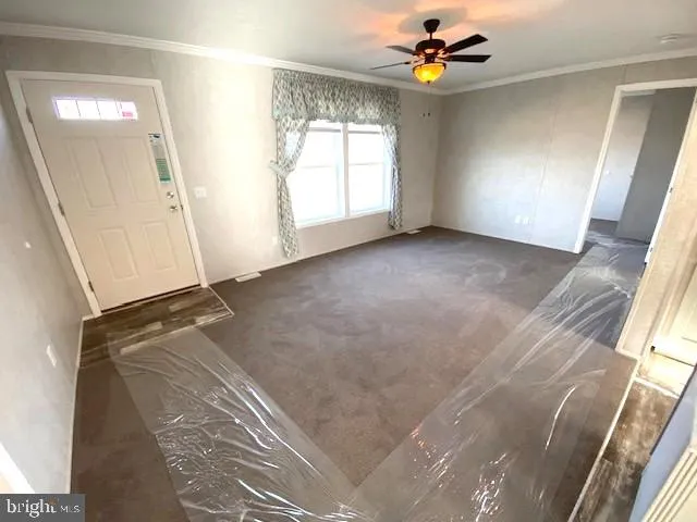 an empty room with windows and fan