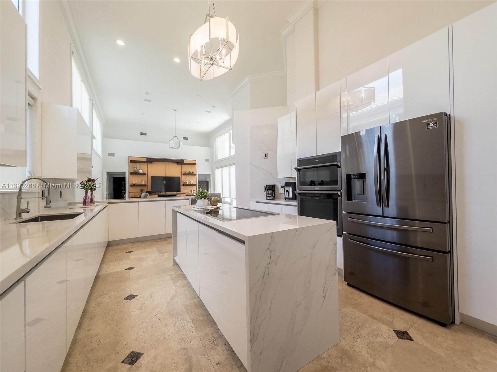 2707 Pinehurst Drive Weston, FL 33332 - Photo 21 of 59 a kitchen with kitchen island white cabinets and stainless steel appliances