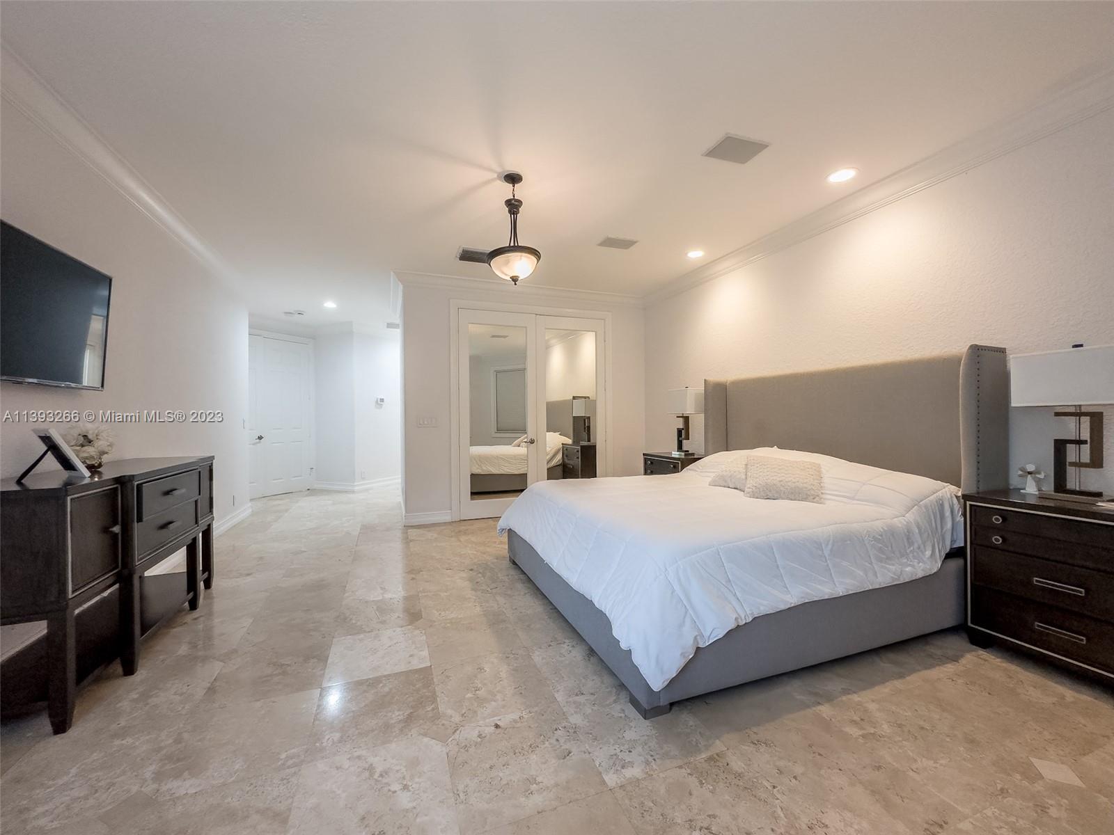 2707 Pinehurst Drive Weston, FL 33332 - Photo 23 of 59 a spacious bedroom with a bed and a flat screen tv