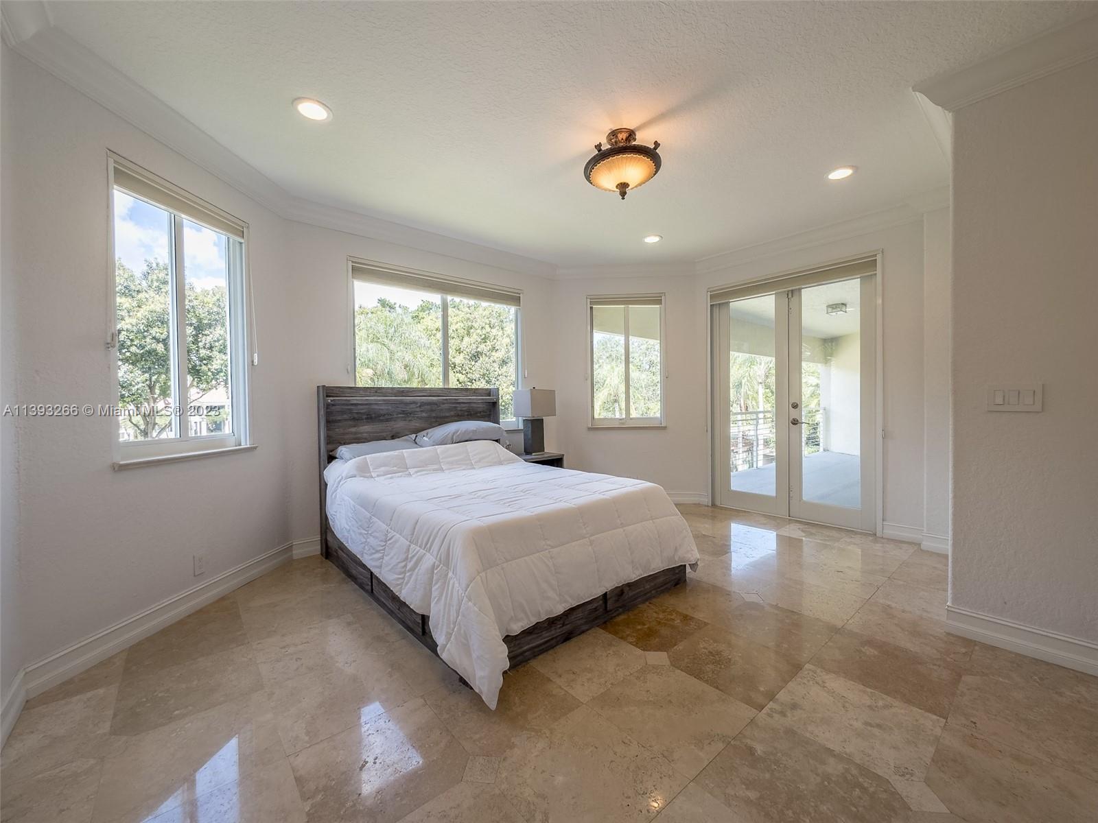 2707 Pinehurst Drive Weston, FL 33332 - Photo 36 of 59 a spacious bedroom with a balcony a bed and a window