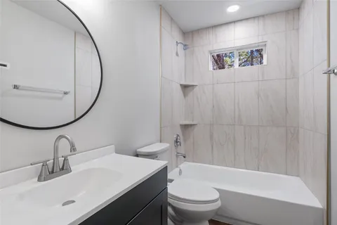 a bathroom with a sink a toilet and a mirror