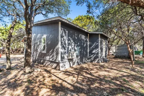 a wooden house with trees in front of it