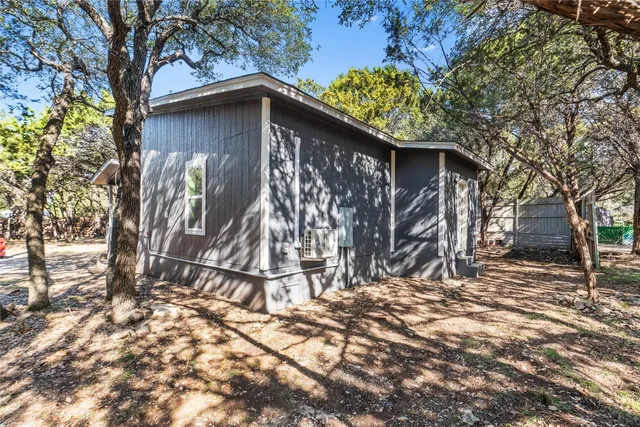 a wooden house with trees in front of it