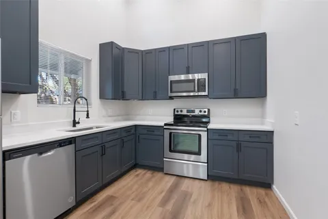 a kitchen with sink a microwave and cabinets