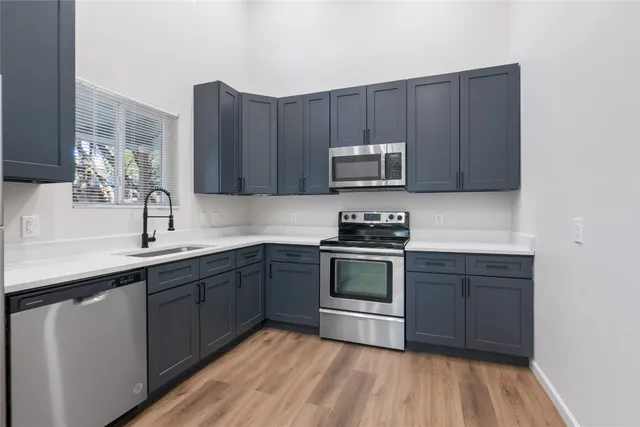 a kitchen with sink a microwave and cabinets
