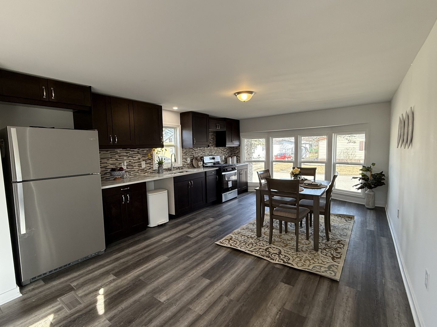 237 Blackthorn Road Matteson, IL 60443 - Photo 3 of 19 a kitchen with a dining table chairs refrigerator and cabinets