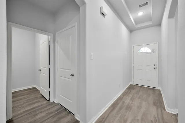 a view of a hallway with wooden floor