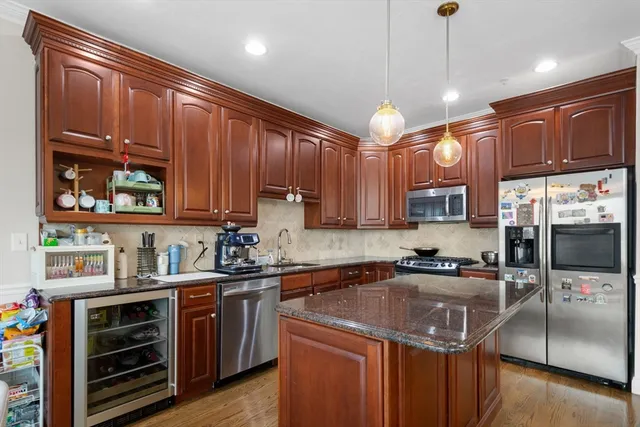 a kitchen with stainless steel appliances granite countertop a sink a stove and a refrigerator