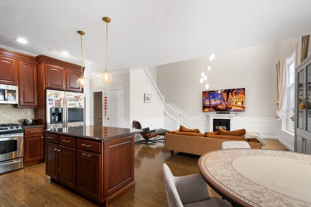 a living room with furniture kitchen view and a wooden floor
