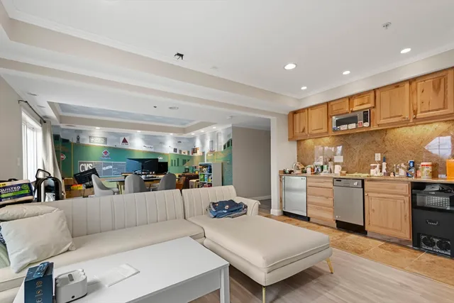 a large living room with stainless steel appliances kitchen island granite countertop a large kitchen island a stove and a refrigerator