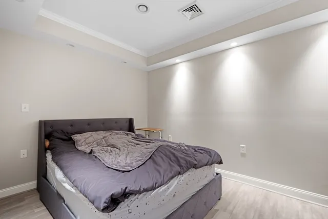 a bedroom with a bed and wooden floor