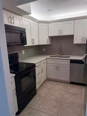 a kitchen with cabinets stainless steel appliances and sink