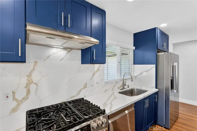 a kitchen with stainless steel appliances granite countertop a sink stove and refrigerator
