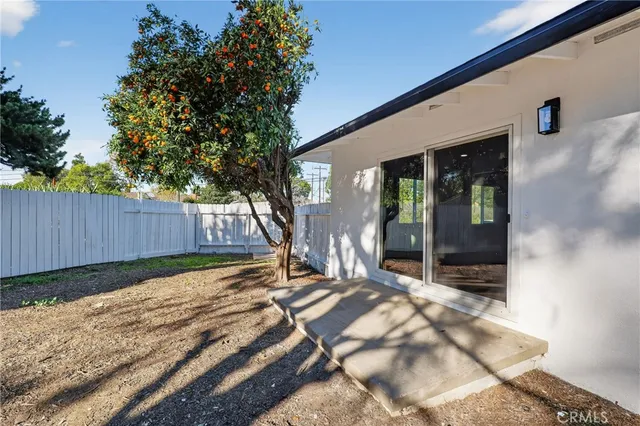 a view of backyard with wooden fence and large trees