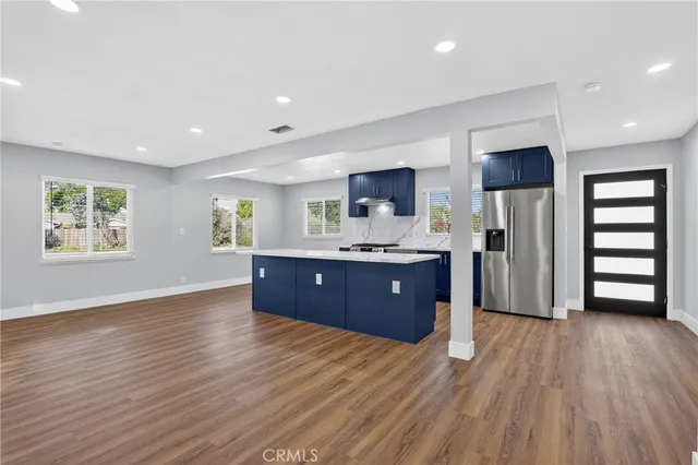 an empty room with a kitchen view and a window