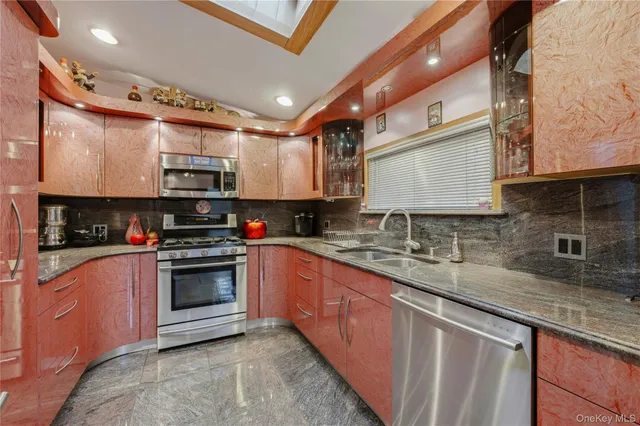 a kitchen with stainless steel appliances granite countertop a sink a stove a microwave and cabinets