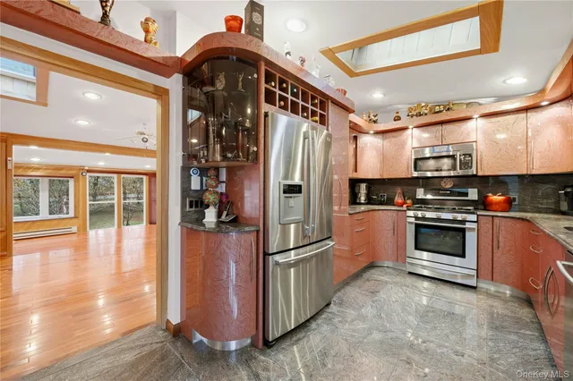 a kitchen with stainless steel appliances granite countertop a refrigerator a stove and a sink